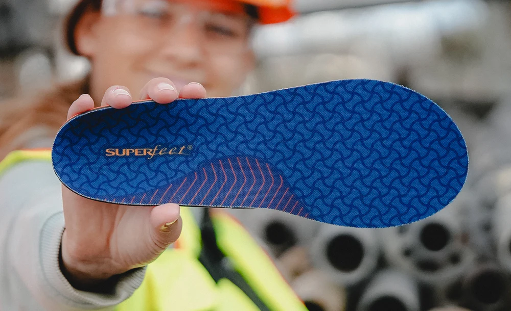 View8_Work_Cushion_2731x1667_366b8149-ea15-49a8-96ce-1e0244b8c658 - Horizon Industries Blue Superfeet orthotic insole with a geometric pattern, held up by a person in a workshop setting.